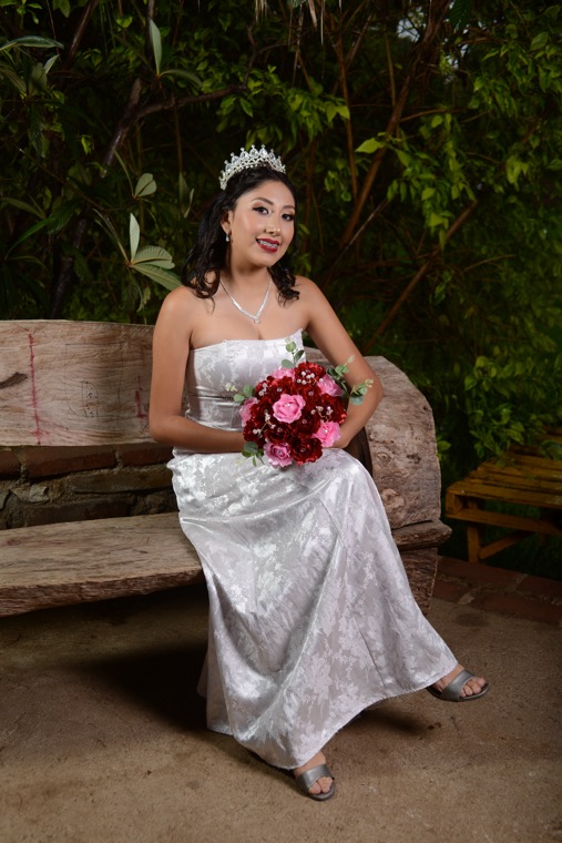 Fernanda sentada con vestido blanco y bouquet